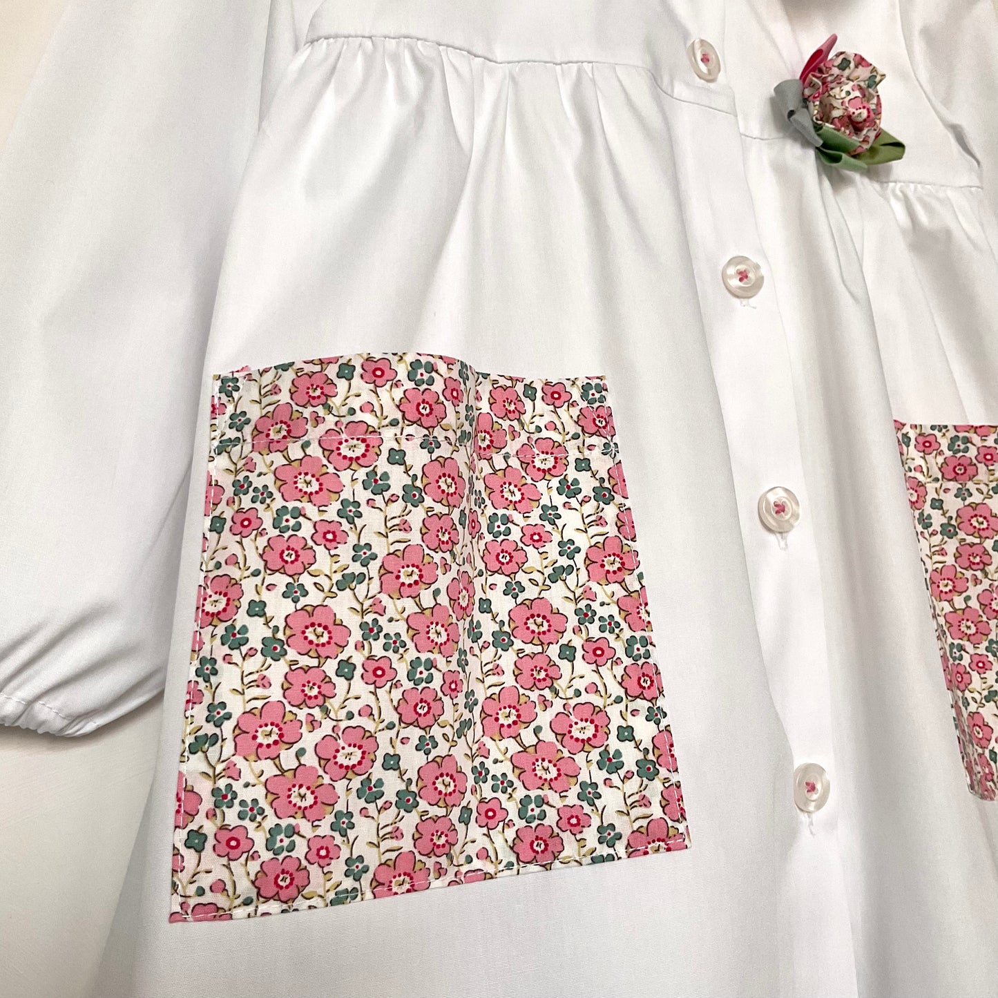 Il grembiulino con i fiori rosa e i nontiscordardime - Grembiule bianco per asilo con tasche a fiorellini rosa